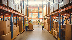 Retail Warehouse full of Shelves with Goods in Cardboard Boxes, Workers Scan and Sort Pack