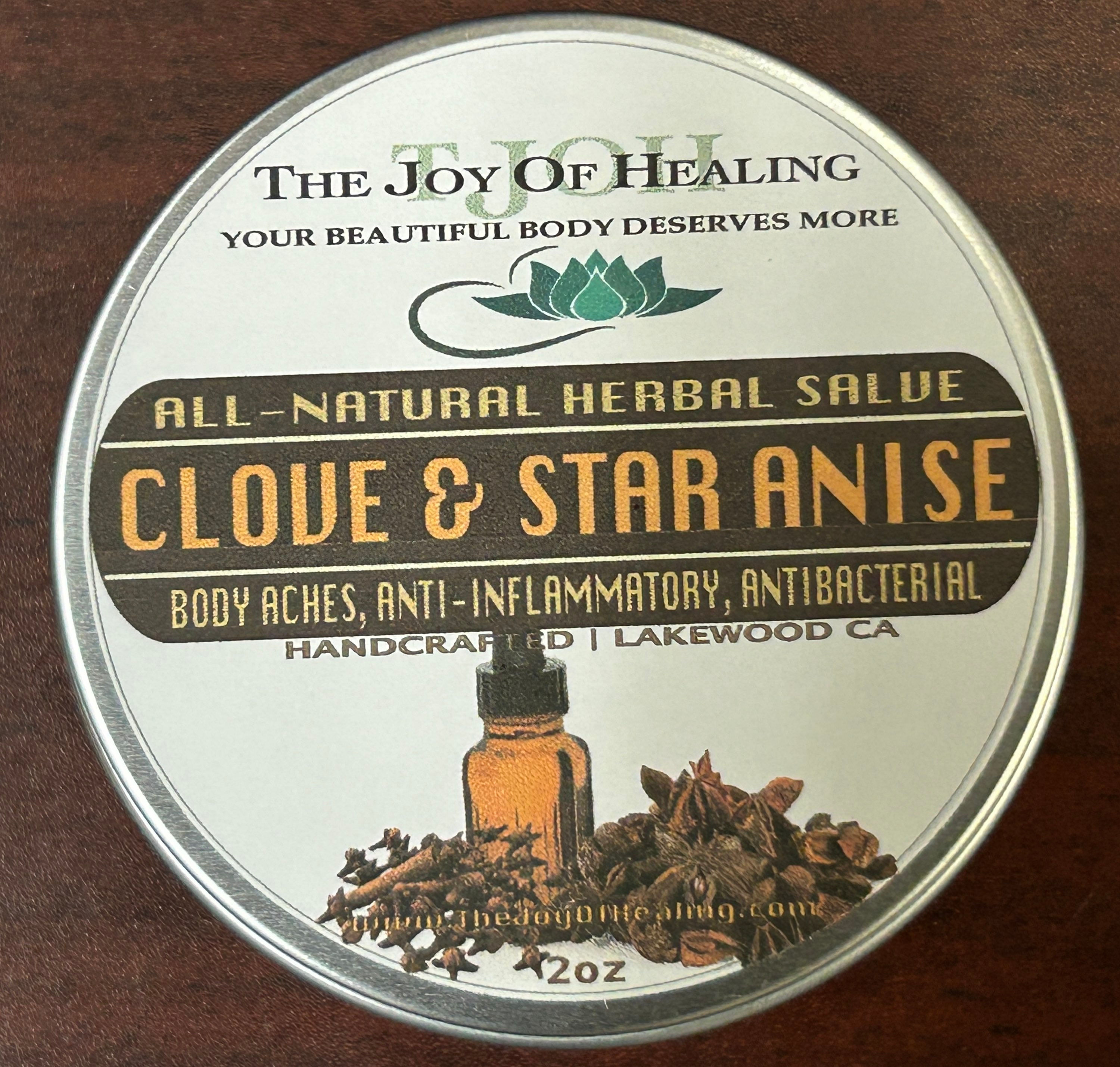 A handcrafted tin of All-Natural Clove & Star Anise Herbal Salve by The Joy of Healing infused with clove and olive oil.