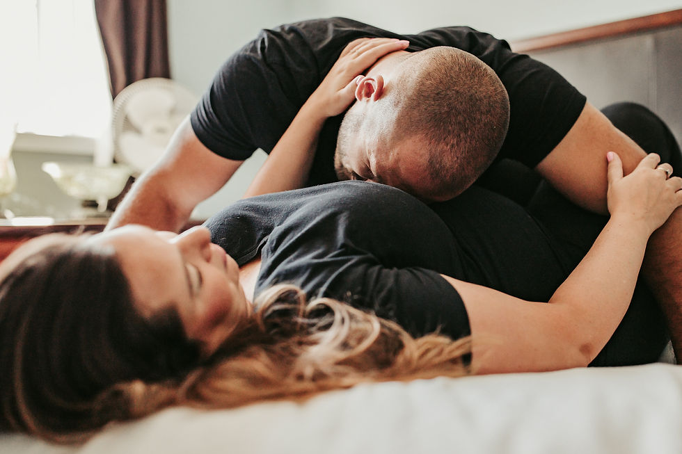 Emotional father laying on pregnant mother's tummy while documenting pregnancy with maternity photography