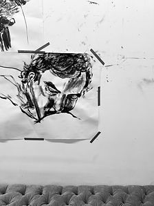 Ink drawing of a man's head pinned to the studio wall.
