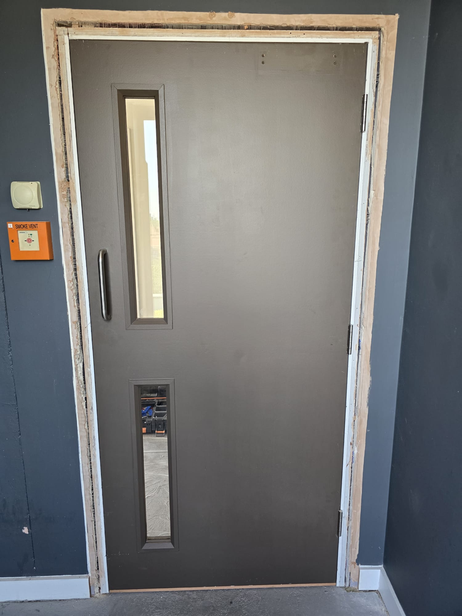 Glazed communal door during frame works, Frampton Park