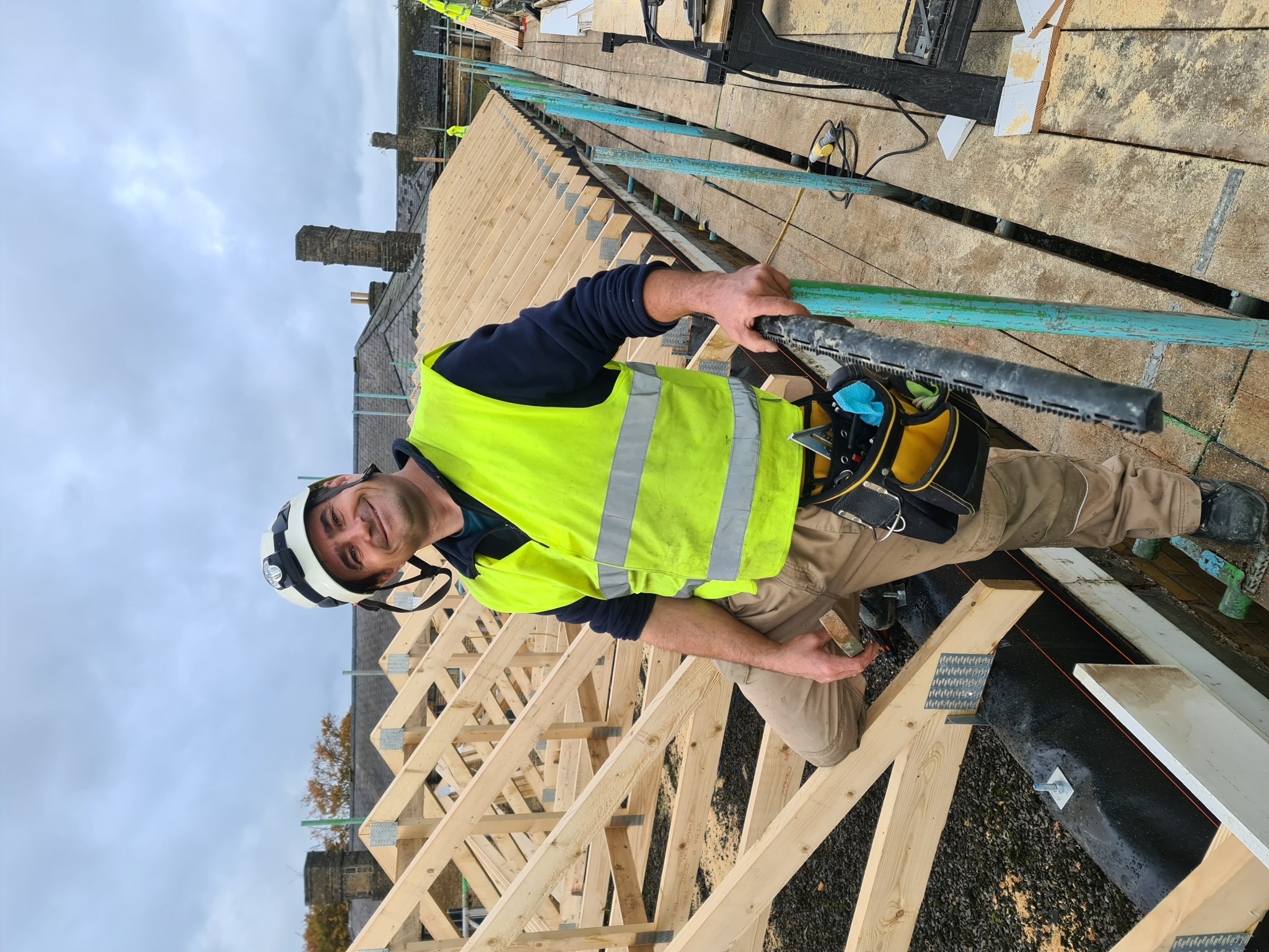 Carpentry team member beside the roof framing, Cambridge Military Hospital