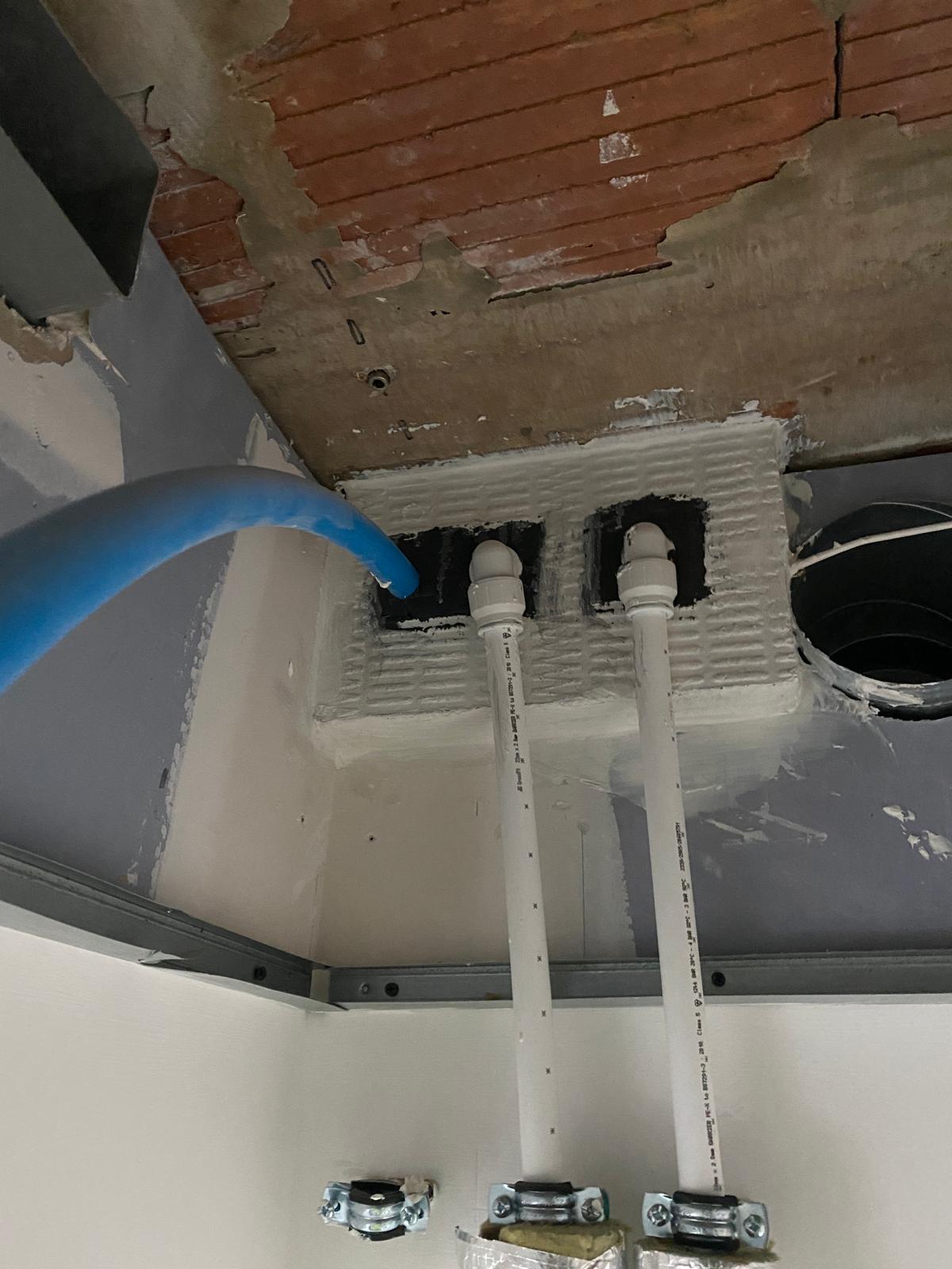 Paired service penetrations above ceiling framing, Cobham firestopping project