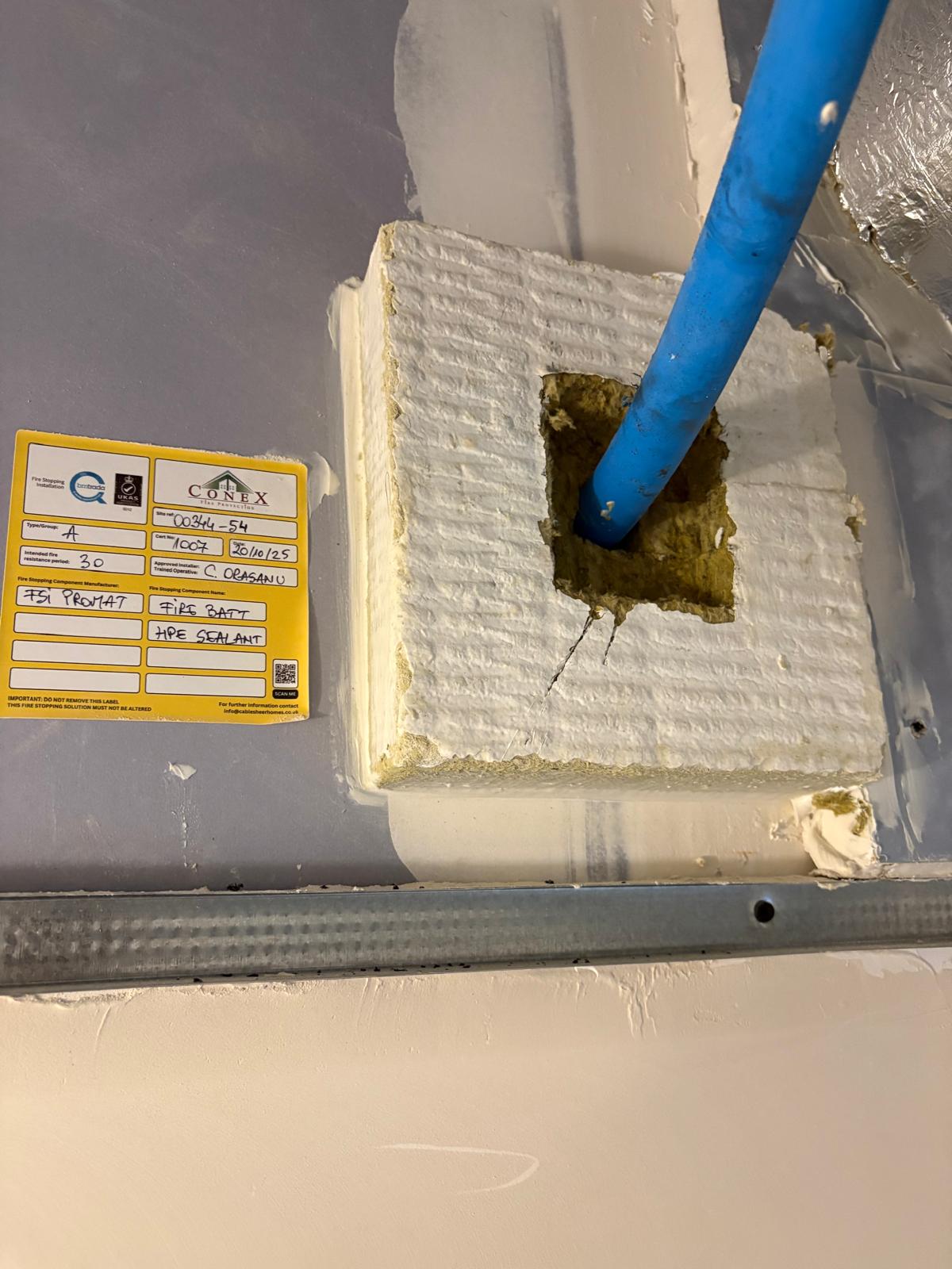 Blue pipe penetration and Conex installation label, Cobham firestopping project