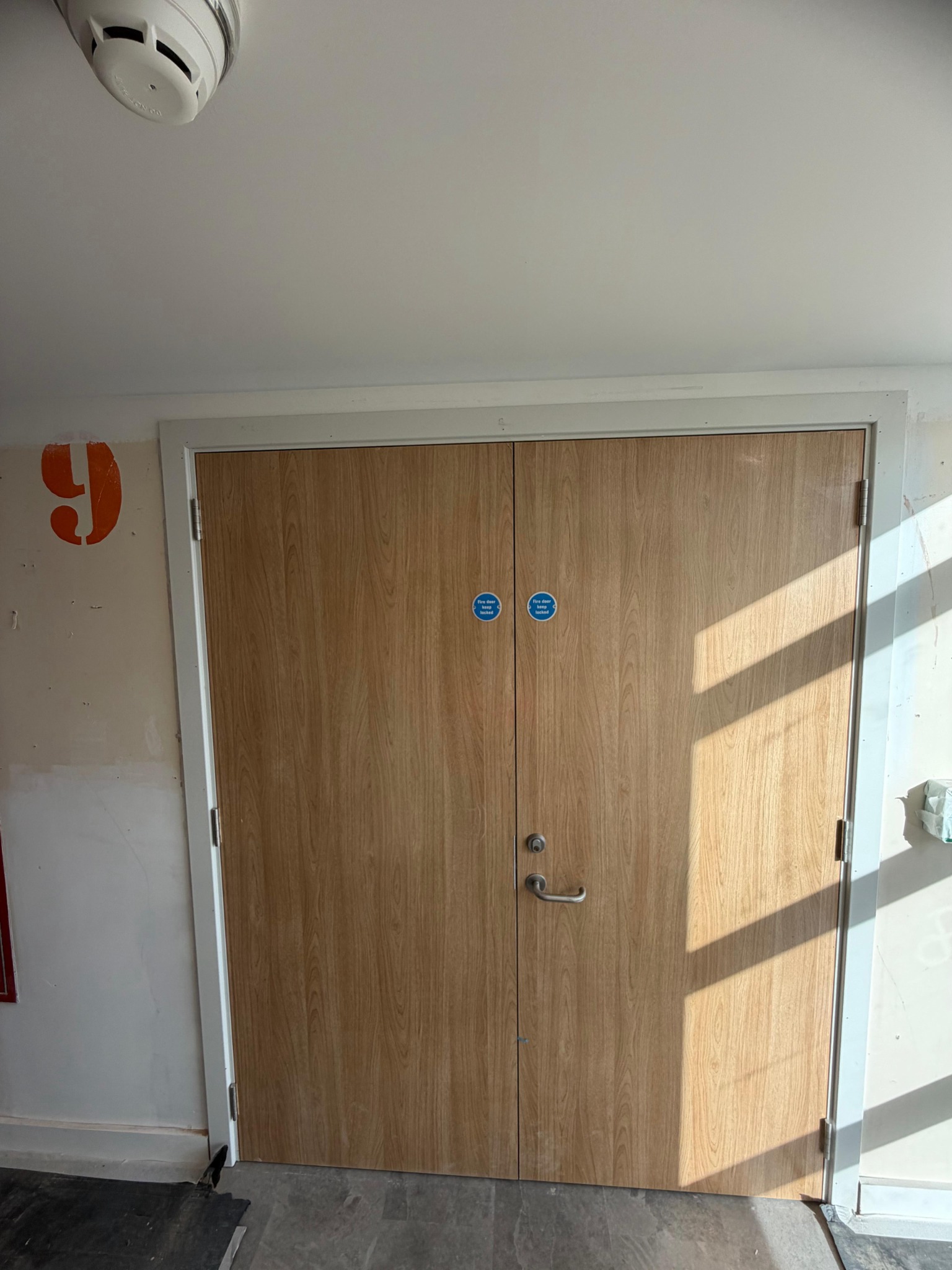 Paired timber doors with fire-door signage, Paragon Estate
