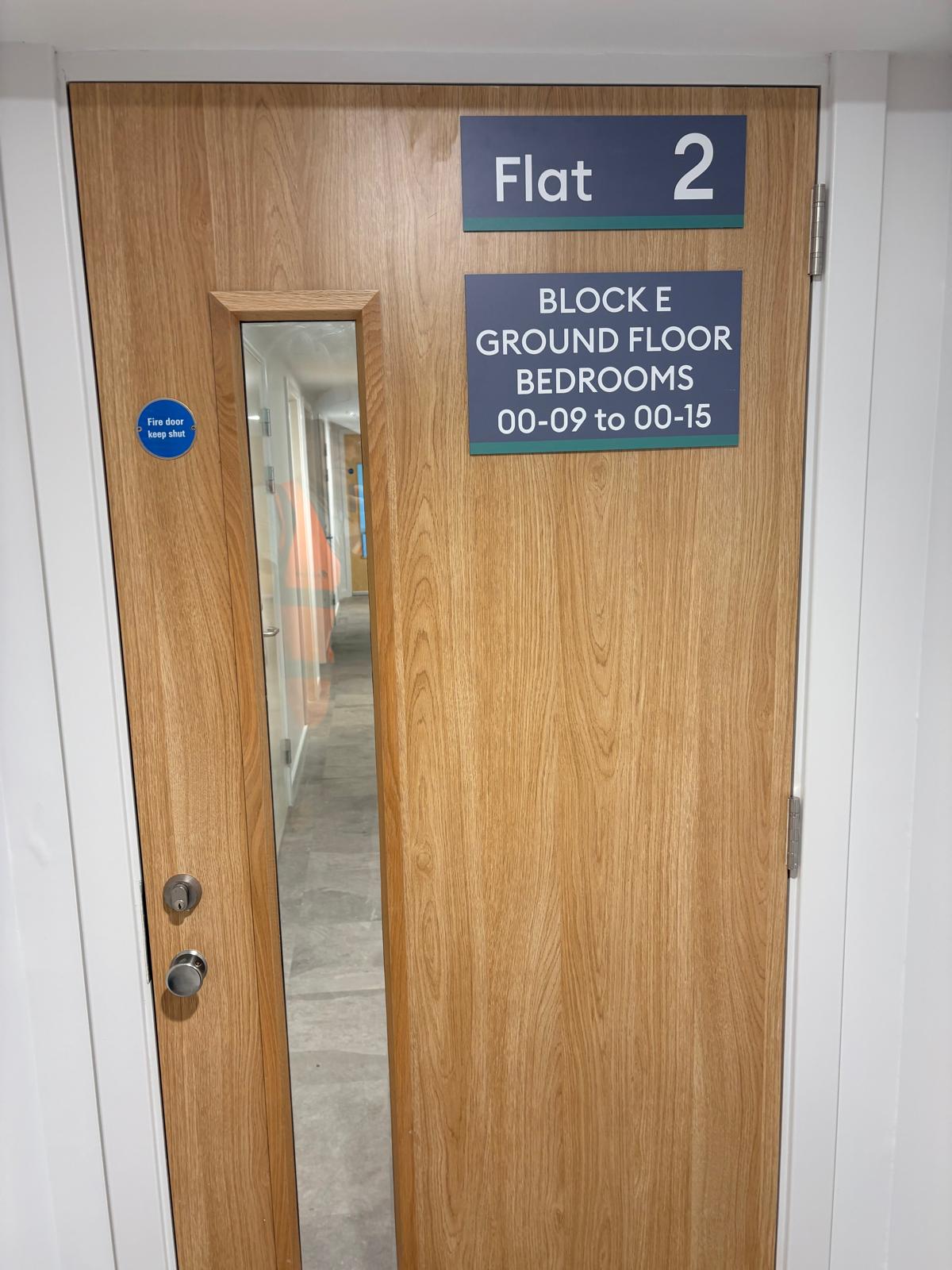 Timber door with vision panel and room signage, Paragon Estate