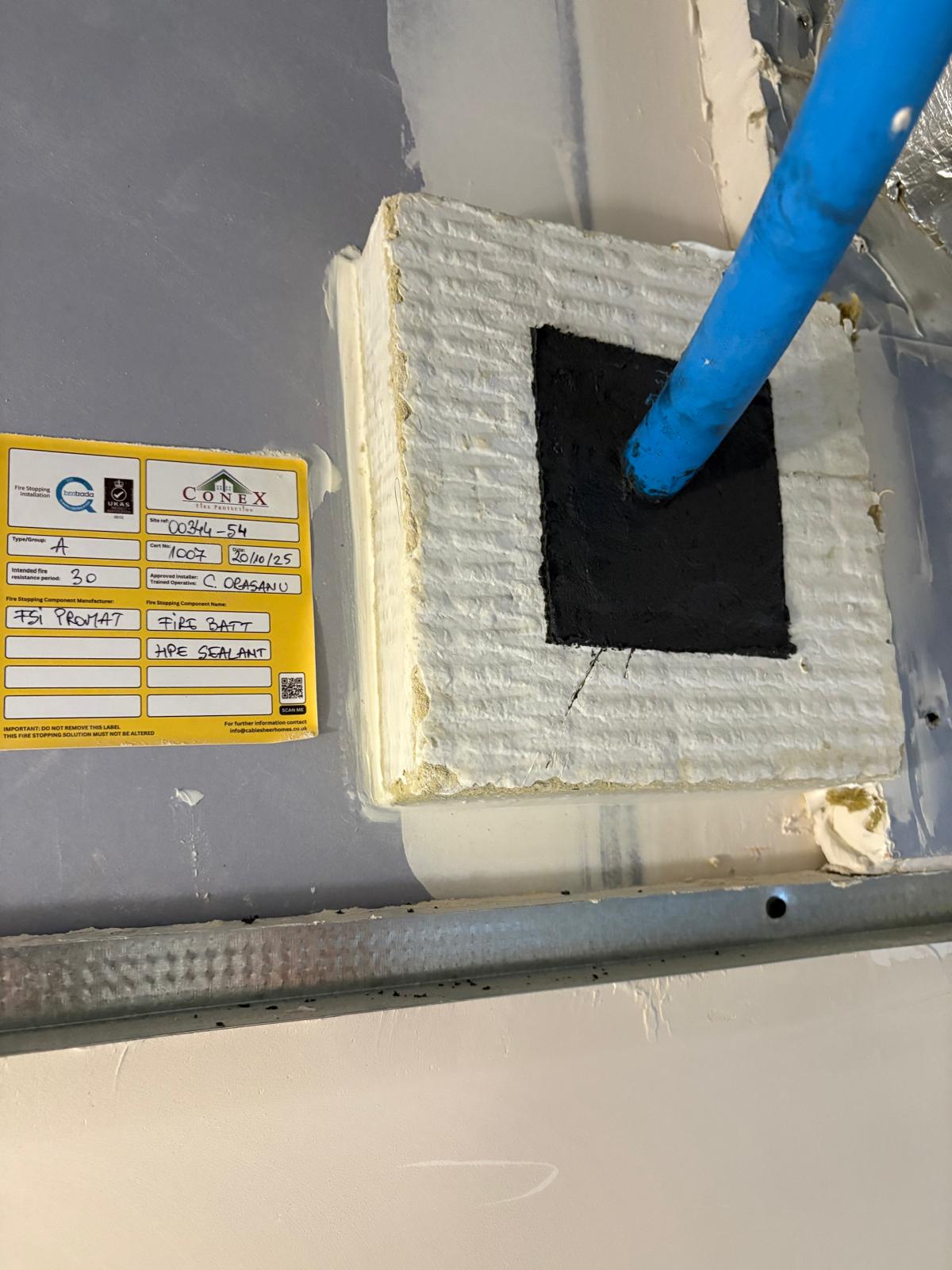 Sealed pipe penetration and Conex installation label, Cobham firestopping project