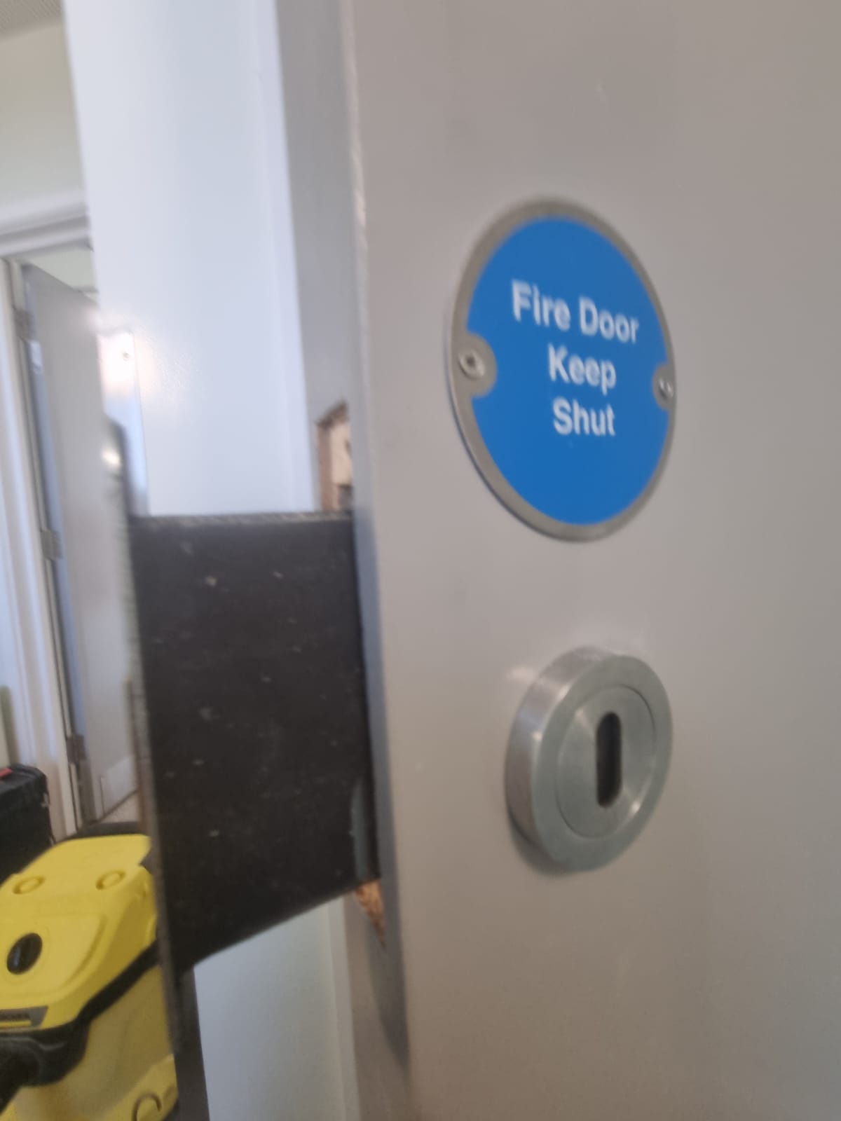 Fire-door signage and keyhole escutcheon detail, Radcliff Court