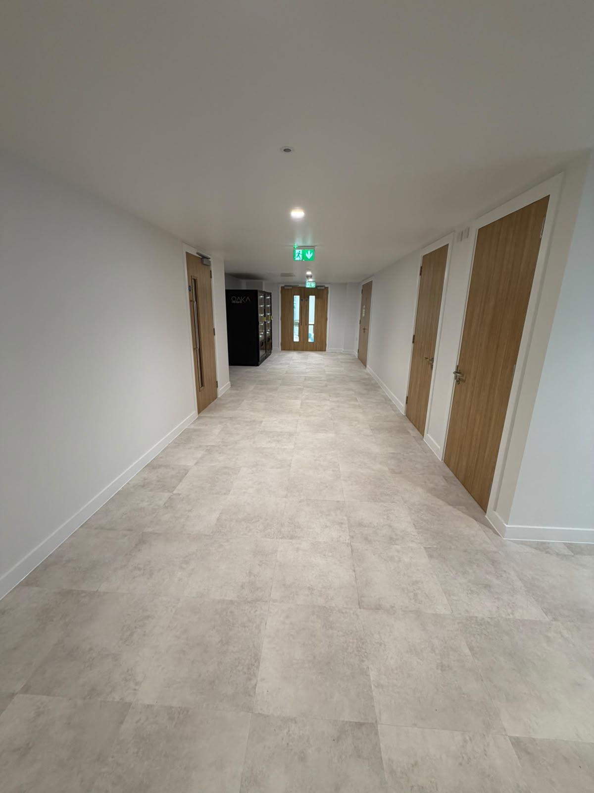Communal corridor with timber doorsets and glazed double doors