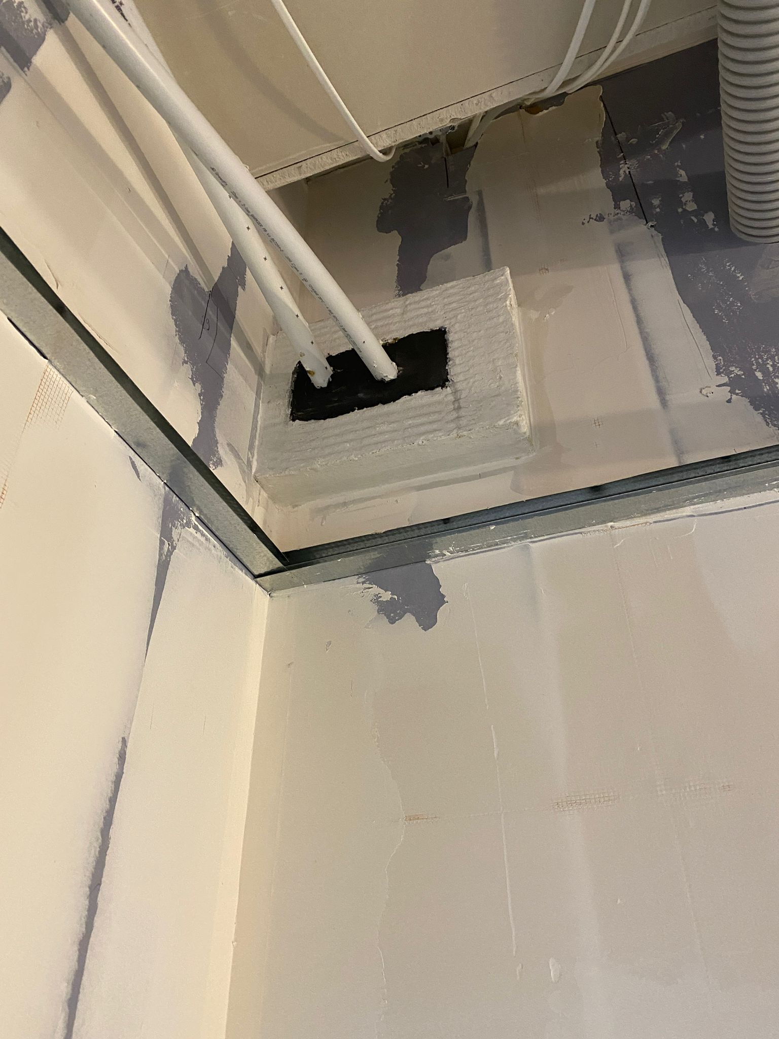 Paired pipe penetrations through a batt panel, Cobham firestopping project