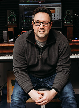Dan sitting in front of a desk.