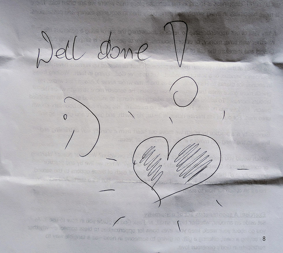 Photo of a handwritten note that says Well done, with a large exclamation mark, smiley face, and a love heart.