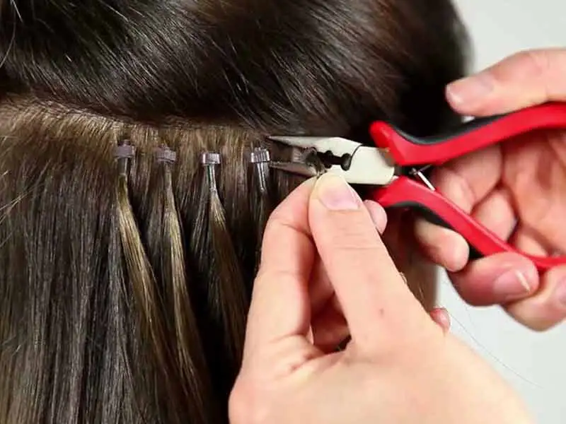 The process requires no glue, heat, or braiding, which can all damage your hair. Instead, each extension is attached to its own copper cylinder. A few strands of your hair are threaded through each cylinder. Once correctly positioned, the ring is then clamped shut using a special tool. This secures your hair to the extension in the cleanest and safest method currently available on the market. And removal and repositioning is just as easy and won’t cause any damage at all.