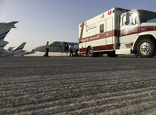 SkyCare Global ground and flight crews on tarmac preparing for patient transfer between ground ambulance to air ambulance