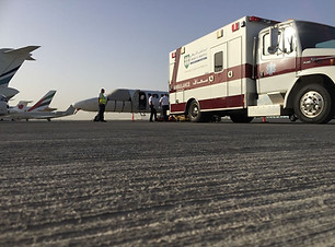 SkyCare Global ground and flight crews on tarmac preparing for patient transfer between ground ambulance to air ambulance