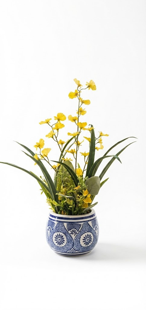 Faux yellow orchid wildflower arrangement in a traditional blue and white porcelain pot on a white background.