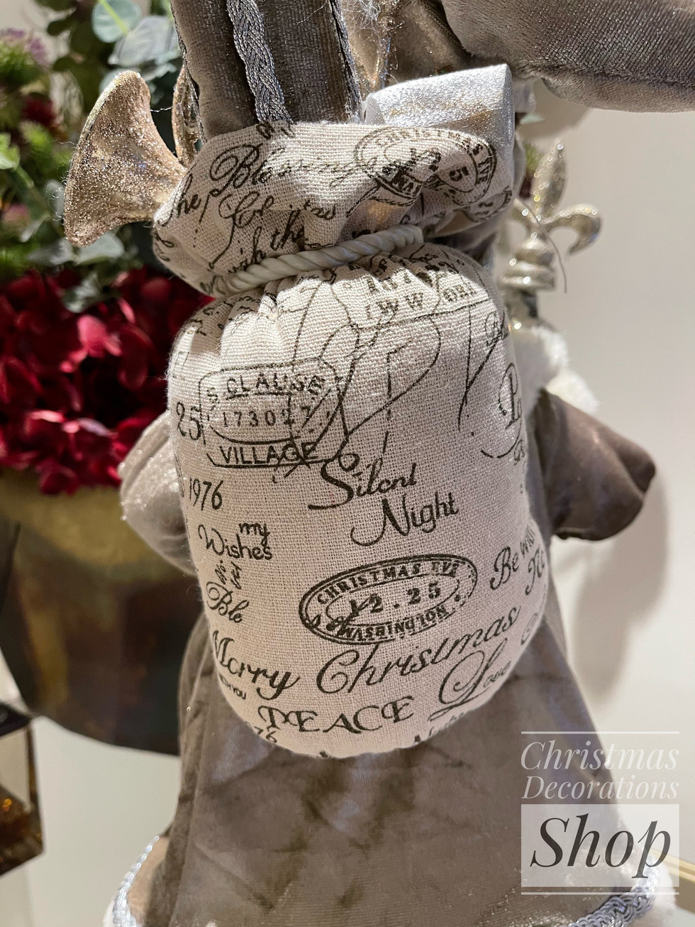 Detailed view of Santa's holiday gift sack printed with vintage postmark stamps holiday words like Silent Night, Christmas