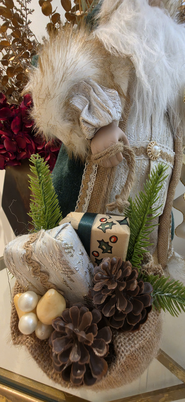 Rustic burlap sack detail filled with wrapped presents, pinecones, and greenery
