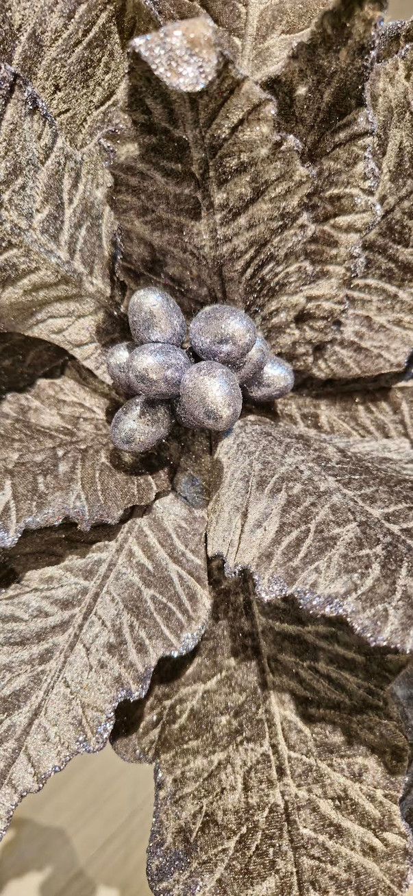 Close-up macro shot of the silver velvet poinsettia petals highlighting the shimmering textured fabric, glitter borders.