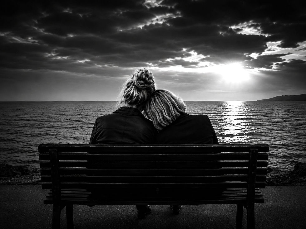 Deux femmes blondes vues de dos sur un banc face à la mer, leurs têtes l’une contre l’autre, illustration du poème Ma nana de Nina Astone