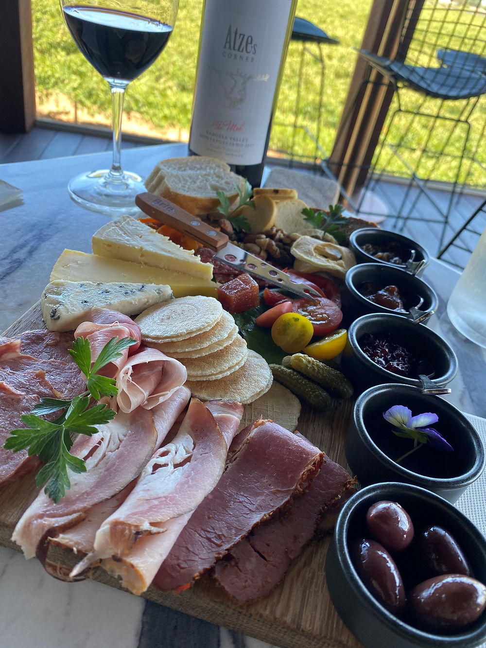 A range of meats, cheeses and crackers on a grazing board