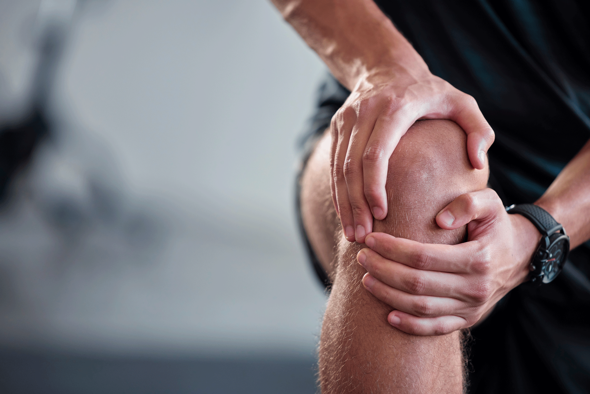 Active man holding painful knee potentially due to Patella or Kneecap Dislocation