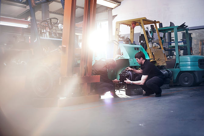 Mechanics examining forklift in auto repair shop.jpg
