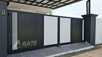 Modern matte black aluminum folding gate installed on a concrete driveway for a residential terrace house.
