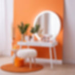 toilet table white with led lamps around the mirror on the desk lay some orange makeup acc
