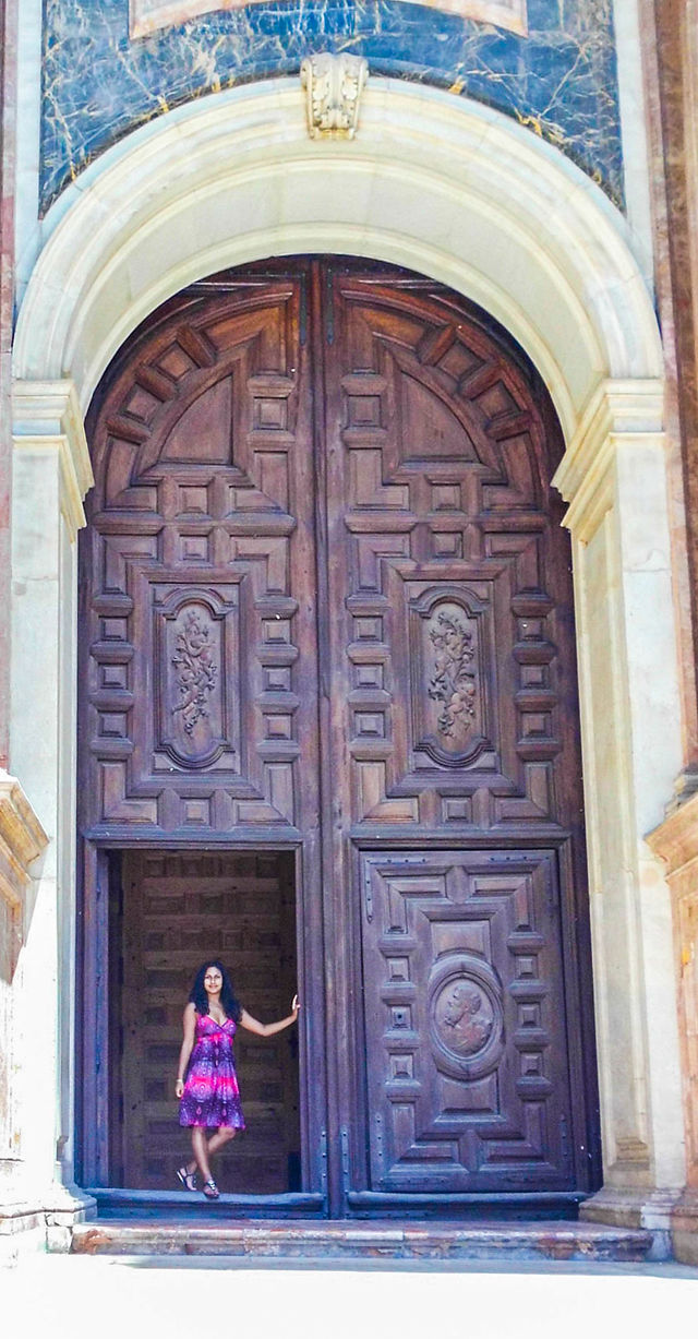 girl standing outside the doors of Cathedral of Málaga