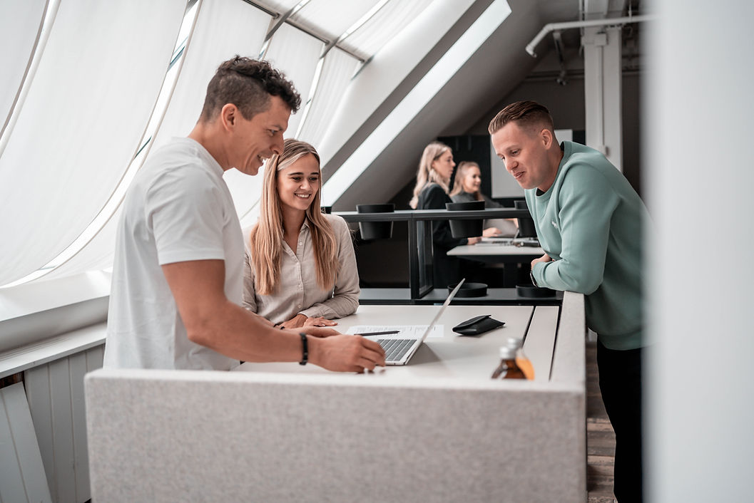 Team von Brise Media arbeitet gemeinsam im Büro, der Gründer steht rechts