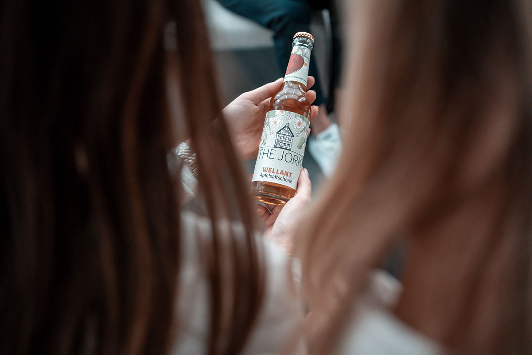 Getränkeflasche der Marke The Jork wird von Teammitgliedern betrachtet