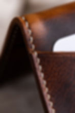 Miniature : Porte-carte en cuir marron avec coutures blanches, gros plan, détail du cuir.