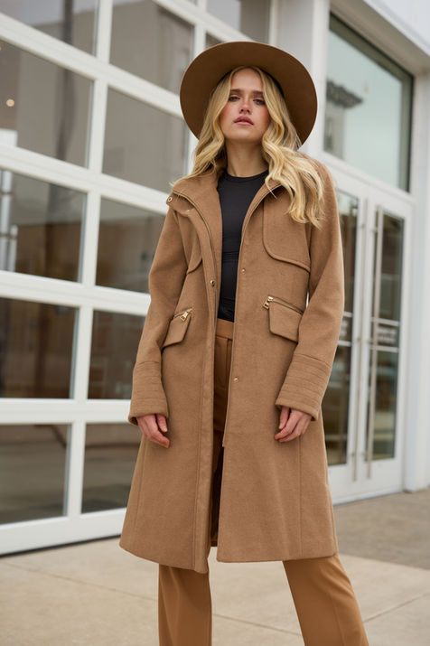 Blonde woman in brown coat and hat, posing outside in FASHION. Nick Johnson Photo