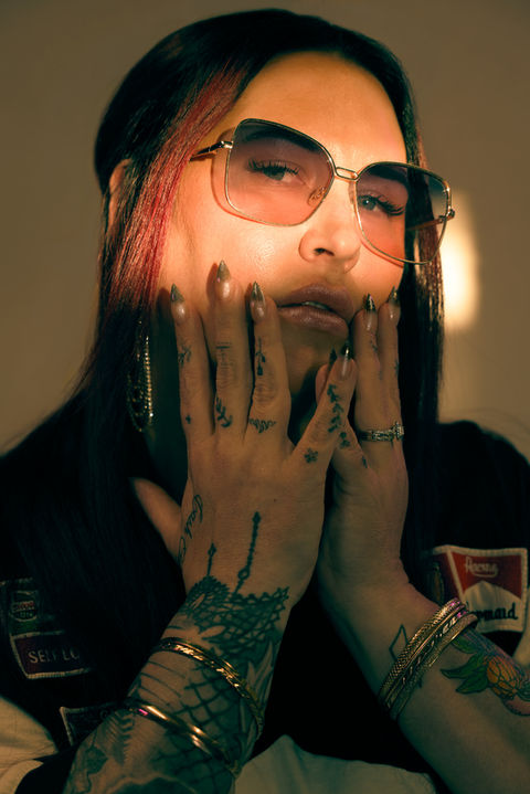 Person wearing sunglasses with tattoos holding face; Nick Johnson Photo.