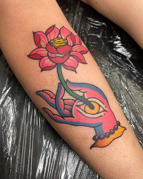 A Neo traditional tattoo of a Tibetan hand holding a lotus flower.