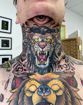 A Neotrad throat tattoo of a lion, skulls and a bear chest piece.