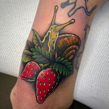 A neotraditional tattoo of a snail and strawberries