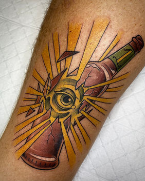 A broken beer bottle containing an eyeball tattoo
