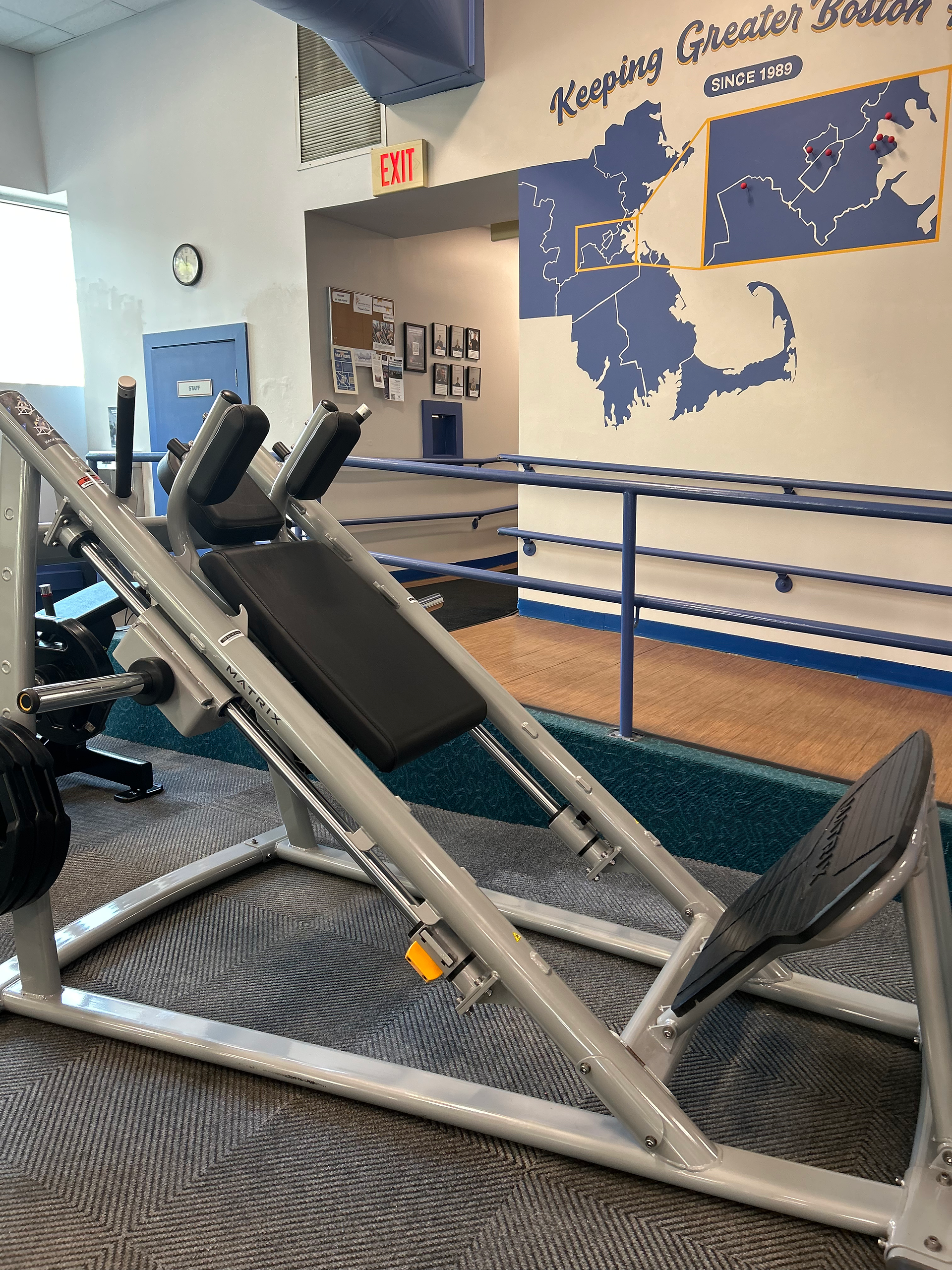 New dumbbells and squat rack at Brookline Village gym free-weight area