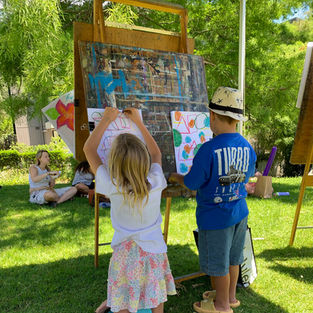 Two children draw on easels