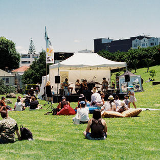The crowd is seen relaxing in front of the main music stage in the sun