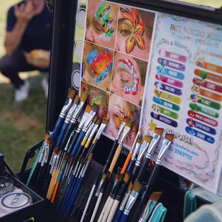 Facepainters table of brushes and pictures to show kids ideas to paint