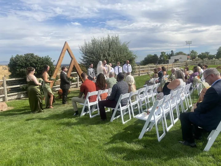 Outdoor ceremony sound, with guests gathered on the lawn.
