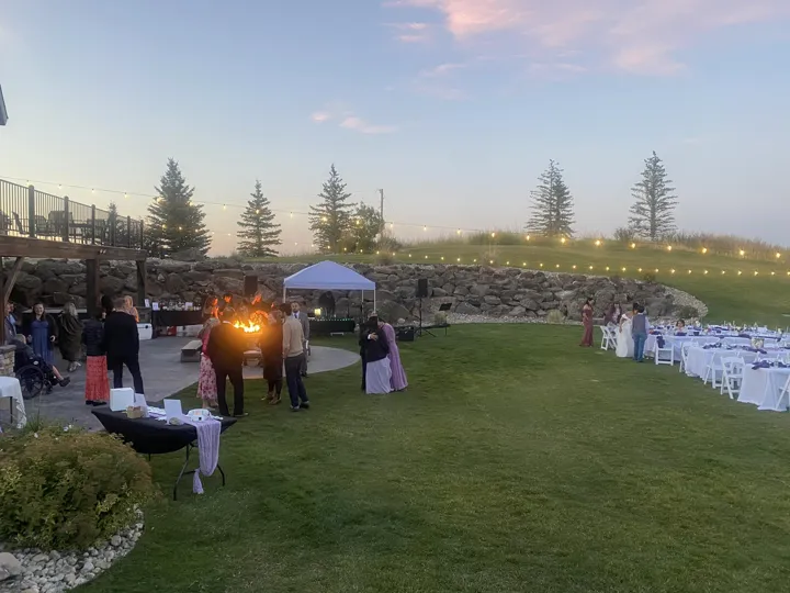 An outdoor wedding reception as evening arrives.
