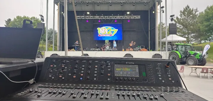 The mixing console facing an outdoor concert stage.