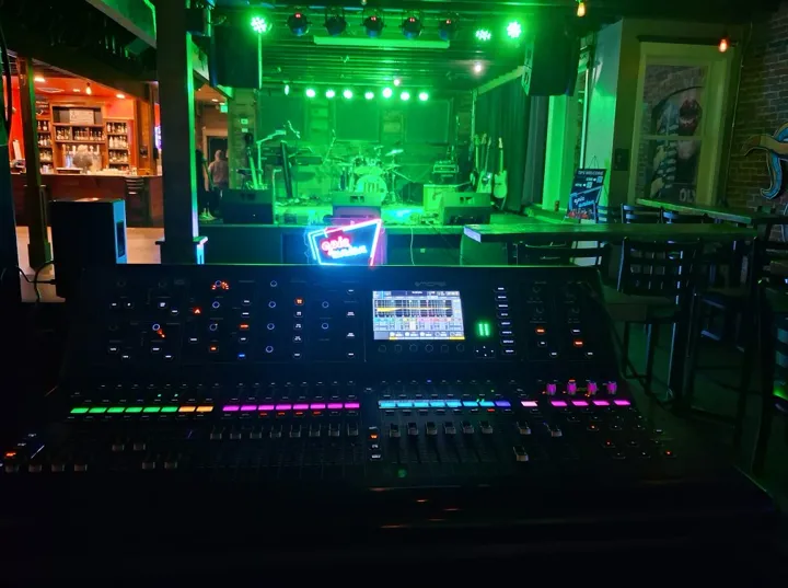The sound desk and stage at an indoor show.