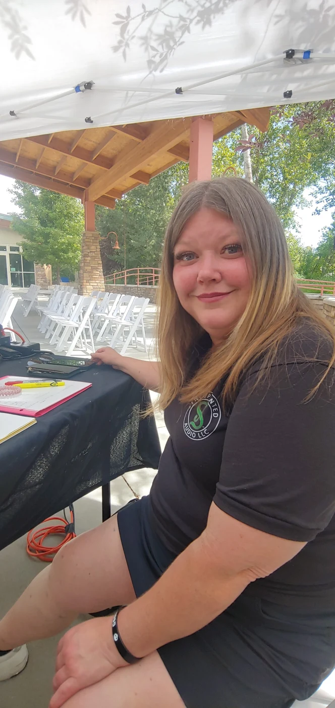 Gina Ramage seated beside an outdoor DJ setup
