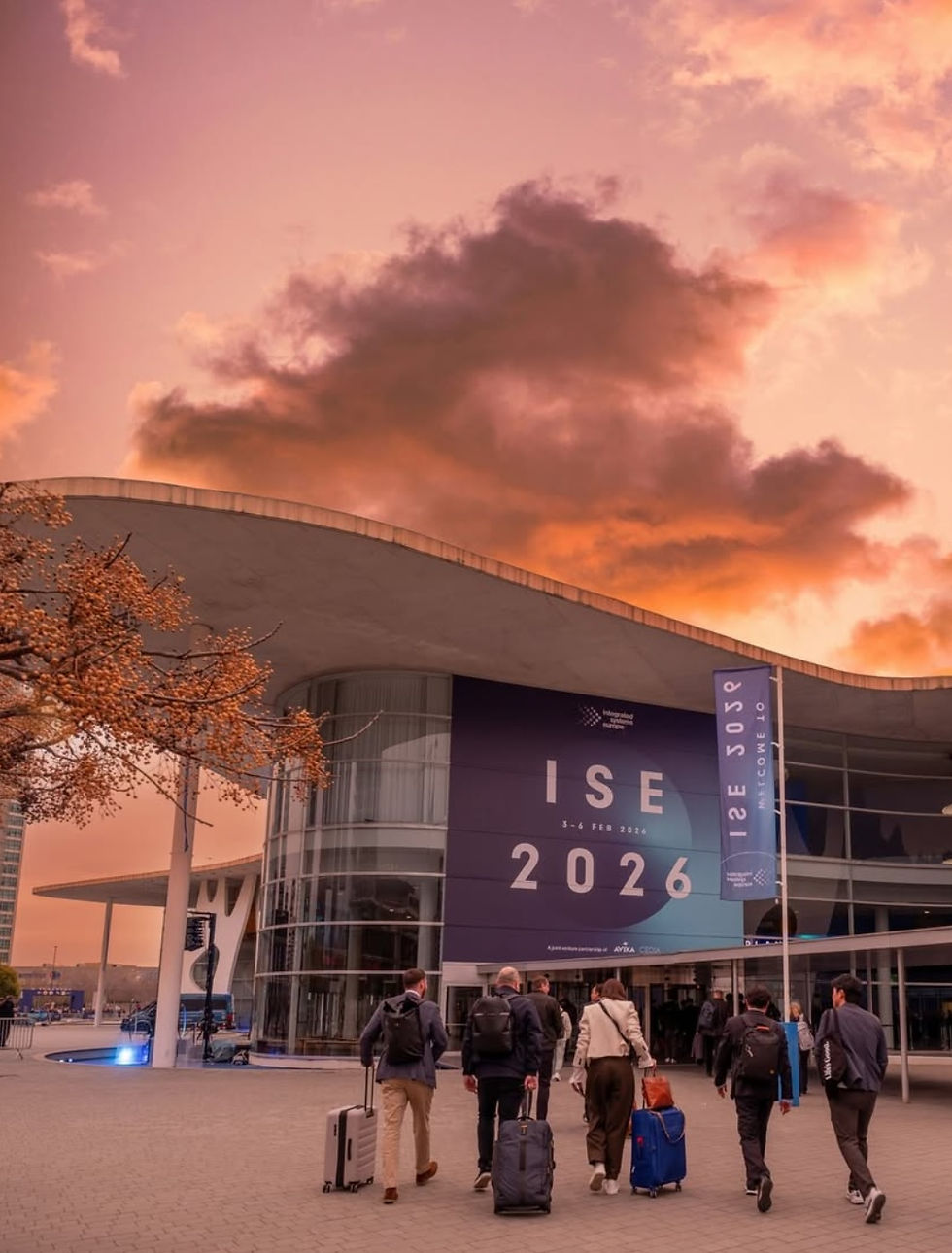 Attendees approach the convention center under a stunning sunset sky for the ISE 2026 event, showcasing the latest in audiovisual innovations.