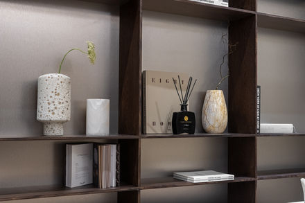 Books and decor arranged on a wooden shelf, Eight Homes, Nu Projects Dubai.